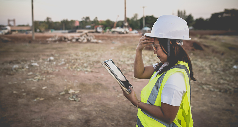 Female construction worker onsite looking at a tablet
